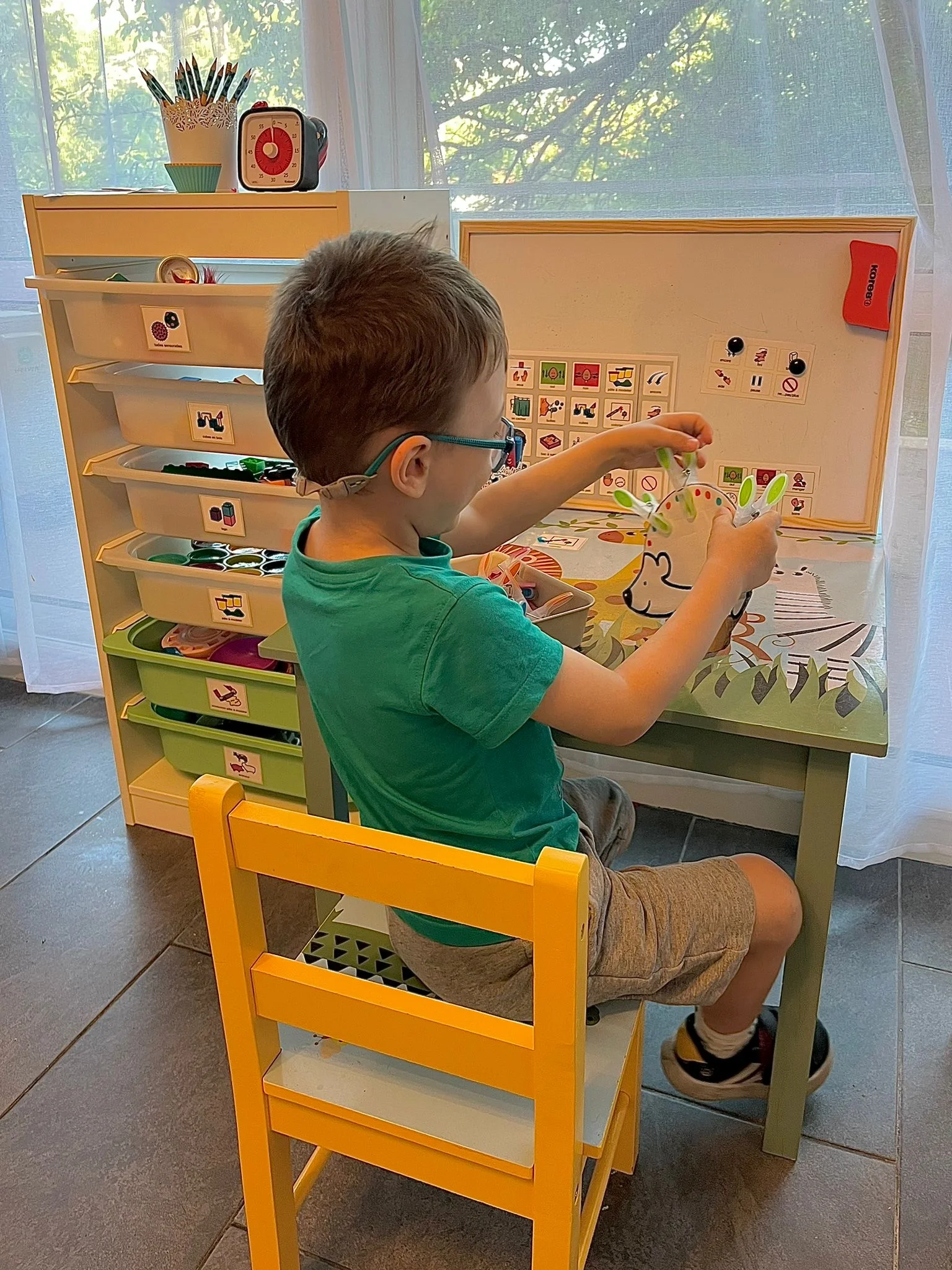 Jeune patient en séance de psychomotricité avec tableau de pictogrammes
